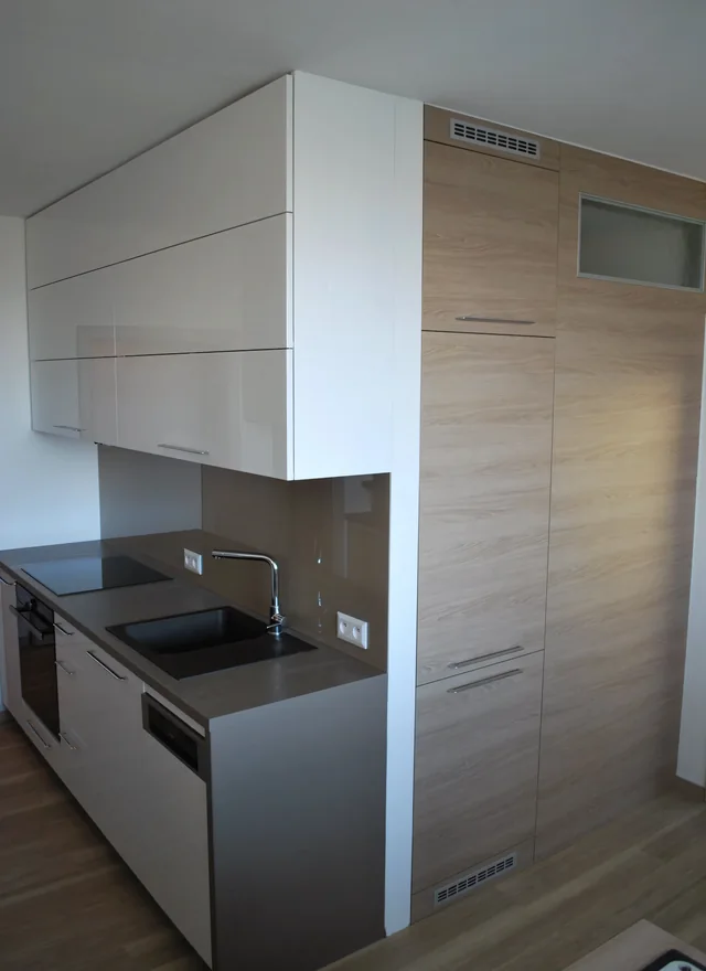 Kuchyňská linka s vysokou skříní v dřevěném dekoru a tmavou deskou