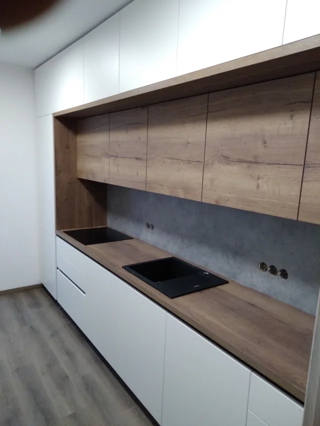 Kuchyňská linka s dřevěnými horními skříňkami a betonovým obkladem