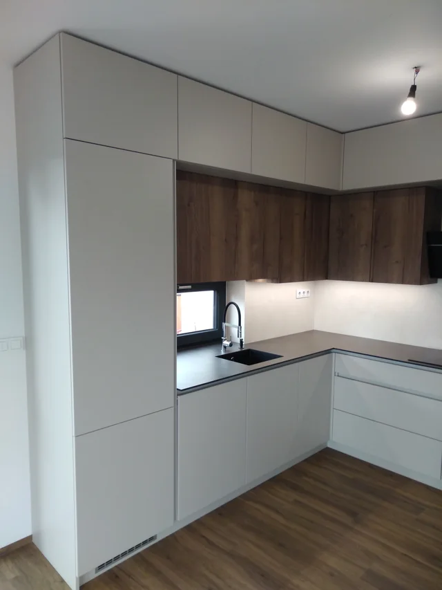 Bílá kuchyň do L s dřevěnou deskou a vysokou skříní